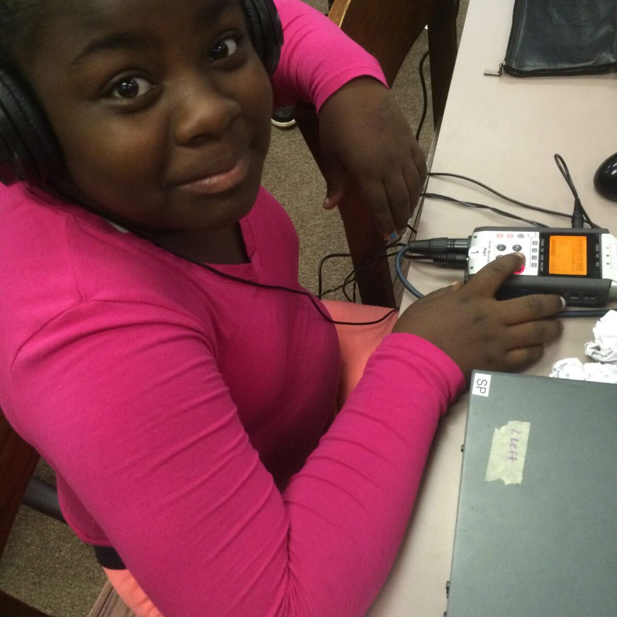 IMG_1872 A youth wearing headphones interacting with a portable recorder sitting at a table