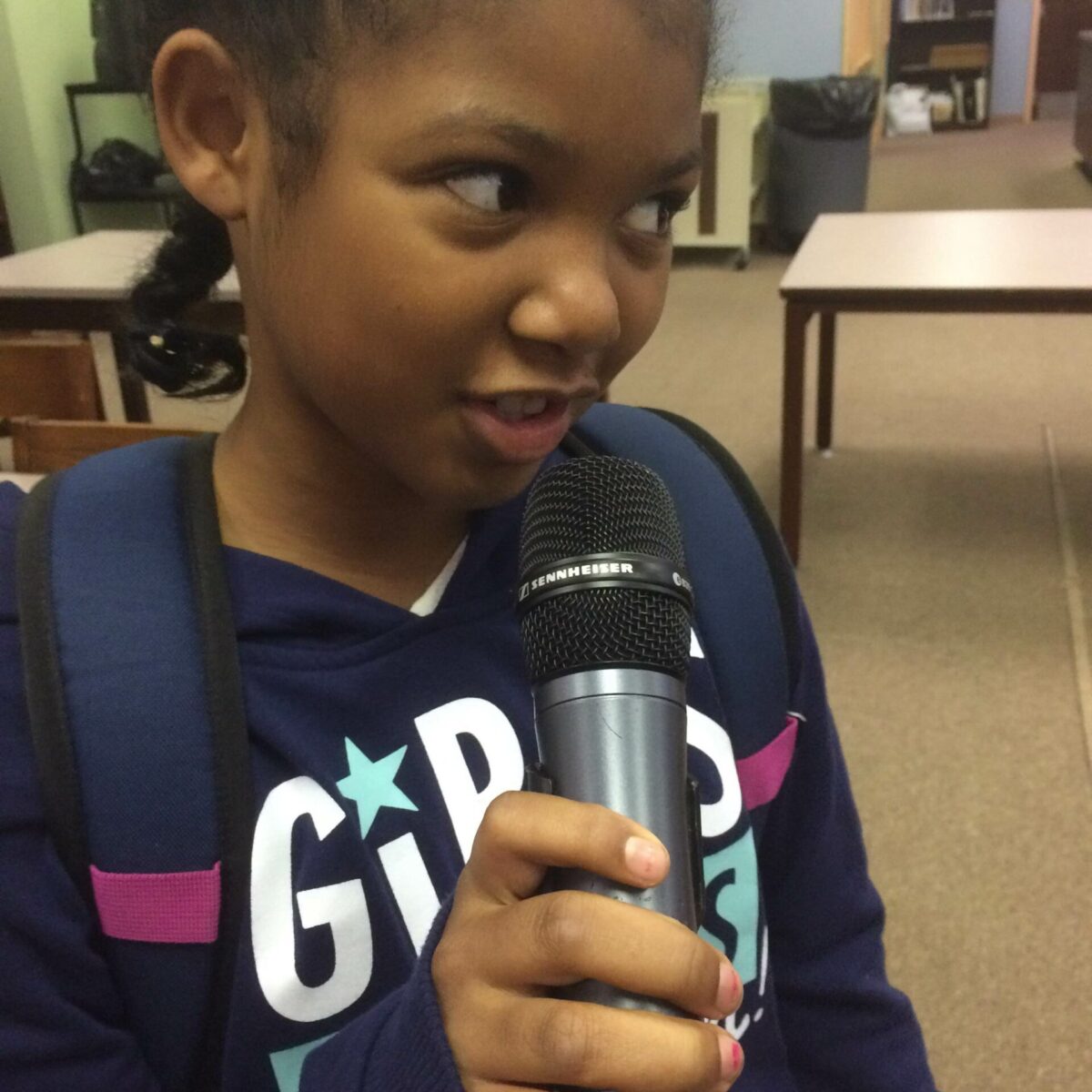 IMG_1876 A youth holding and speaking into a microphone in a library