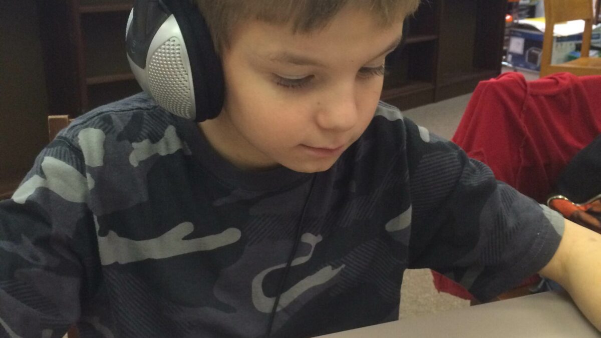 IMG_1979 A youth wearing headphones interacting with a portable recorder in a library