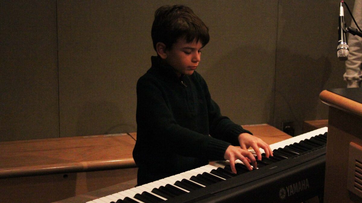 A youth playing a piano keyboard on the Saturday Light Brigade