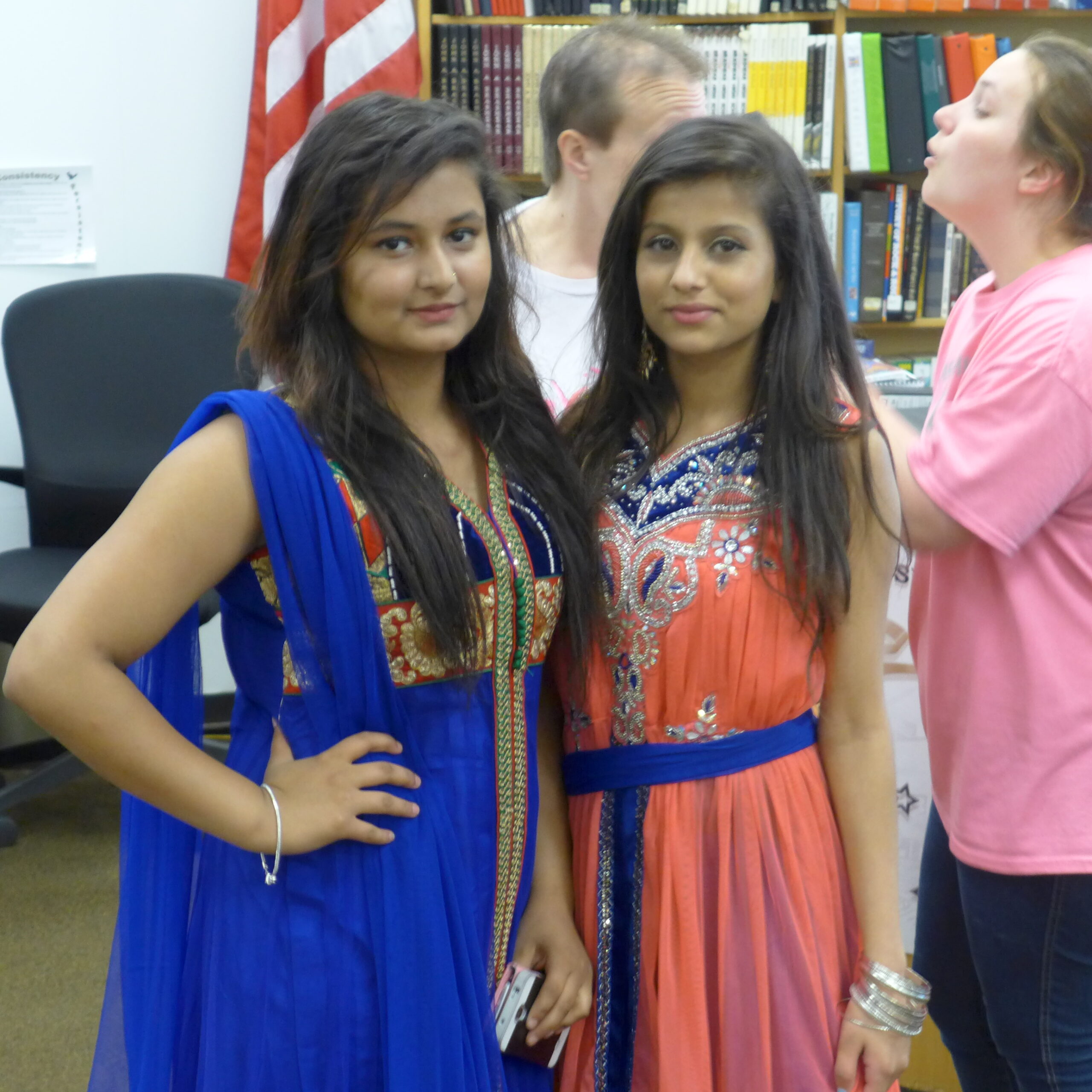 Two individuals looking at the camera standing in profile