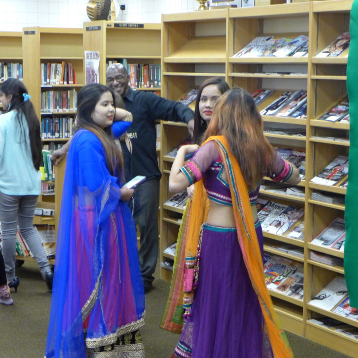 Five individuals standing in a library