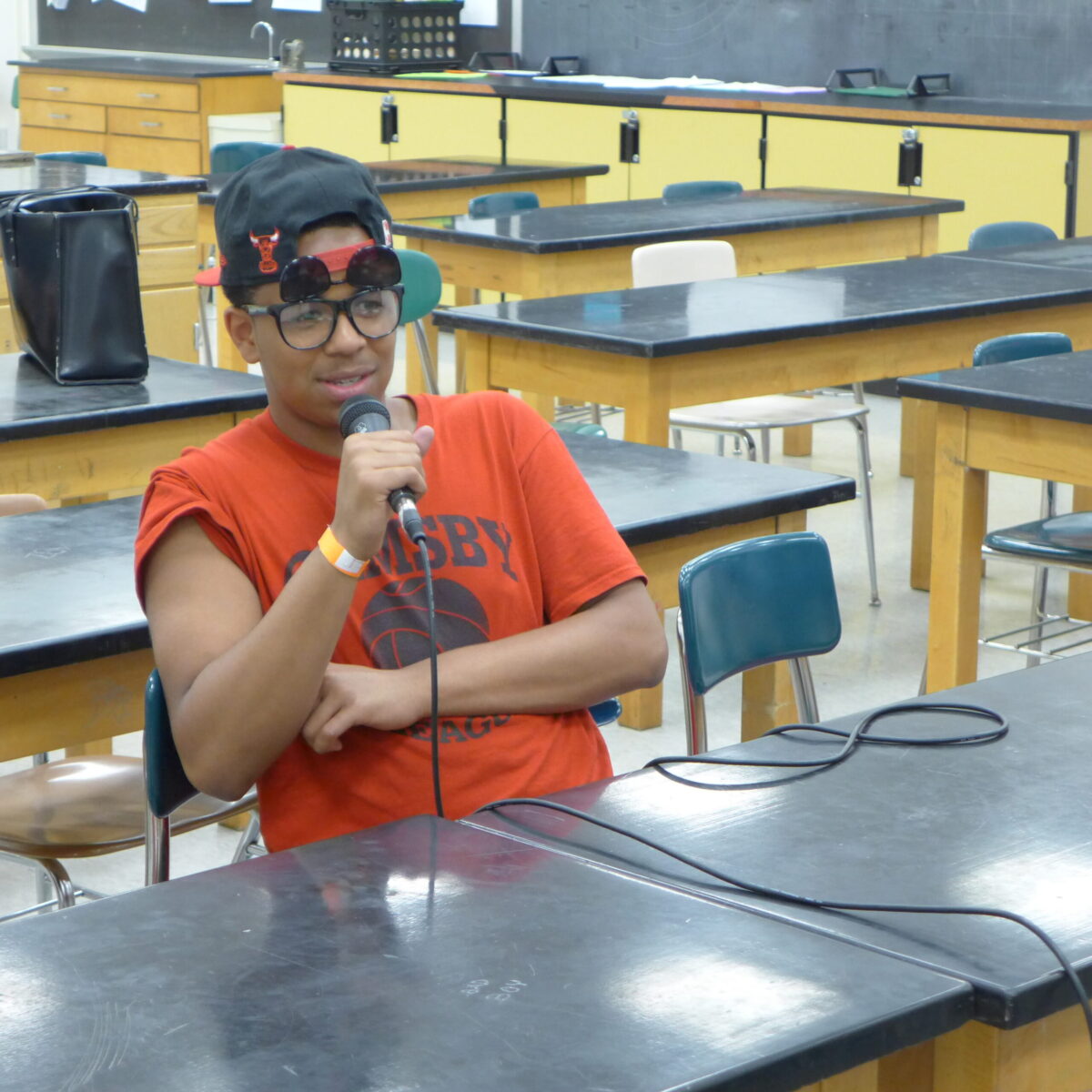 P1020647 A teen holding and speaking into a microphone in a classroom