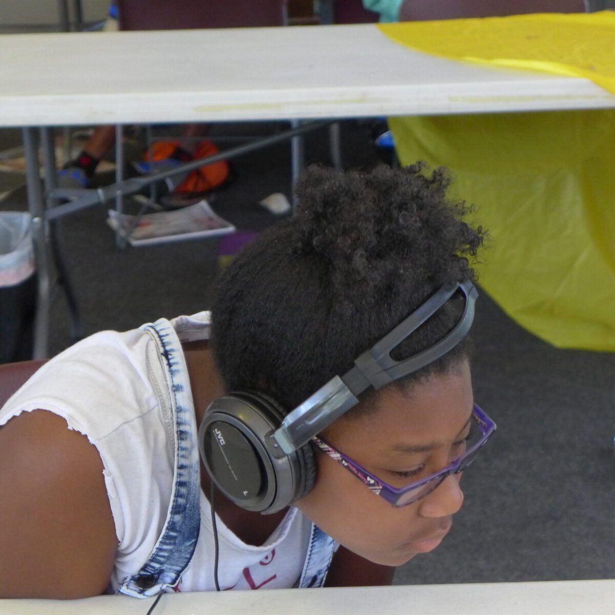 P1020697 A youth wearing headphones looking down at a white table