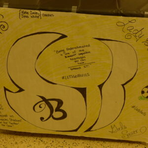 A yellow posterboard signed by various school clubs
