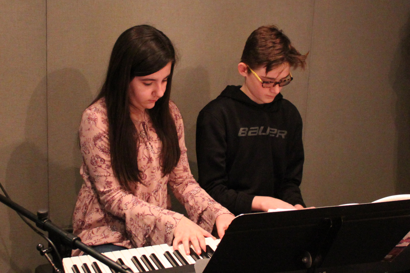 Two youth playing a piano keyboard in a radio studio