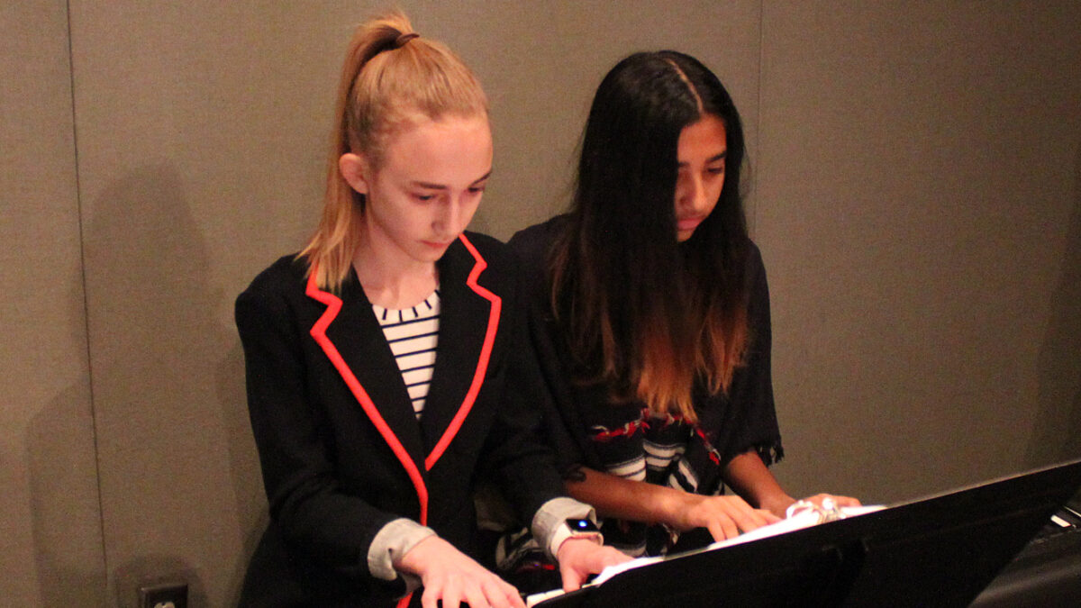 Two youth playing a piano keyboard in a radio studio