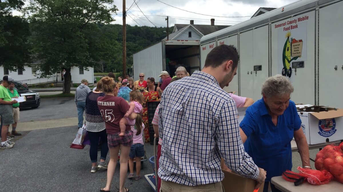 A small crowd of people at a food drive