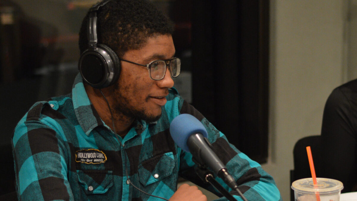Teen wearing headphones speaking into a microphone in a radio studio