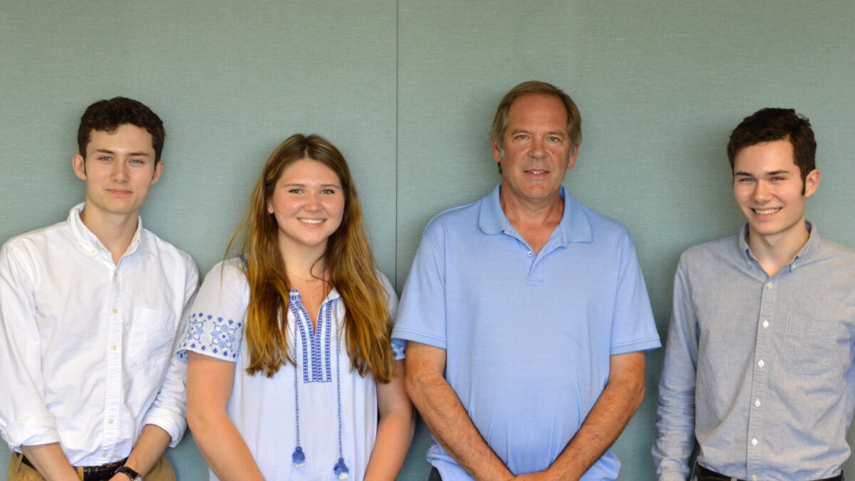 Three teens and one adult smiling and posing in profile