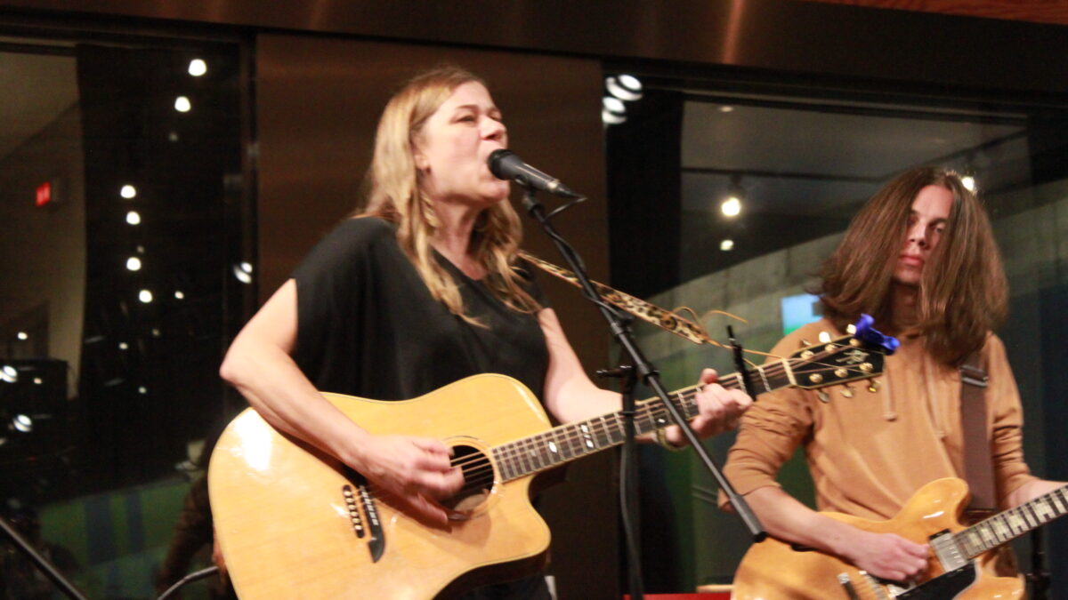 An adult playing guitar and singing into a microphone and an adult playing guitar outside a radio studio
