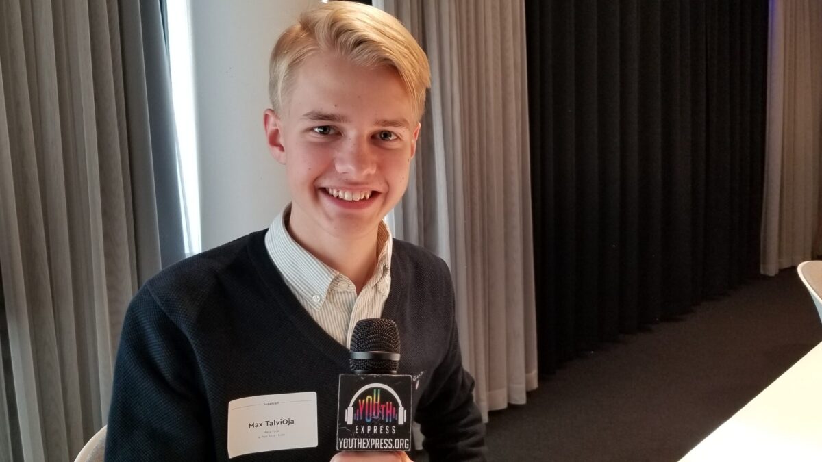 Young adult holding a microphone and smiling in profile