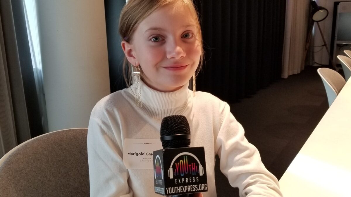Young adult holding a microphone and smiling in profile