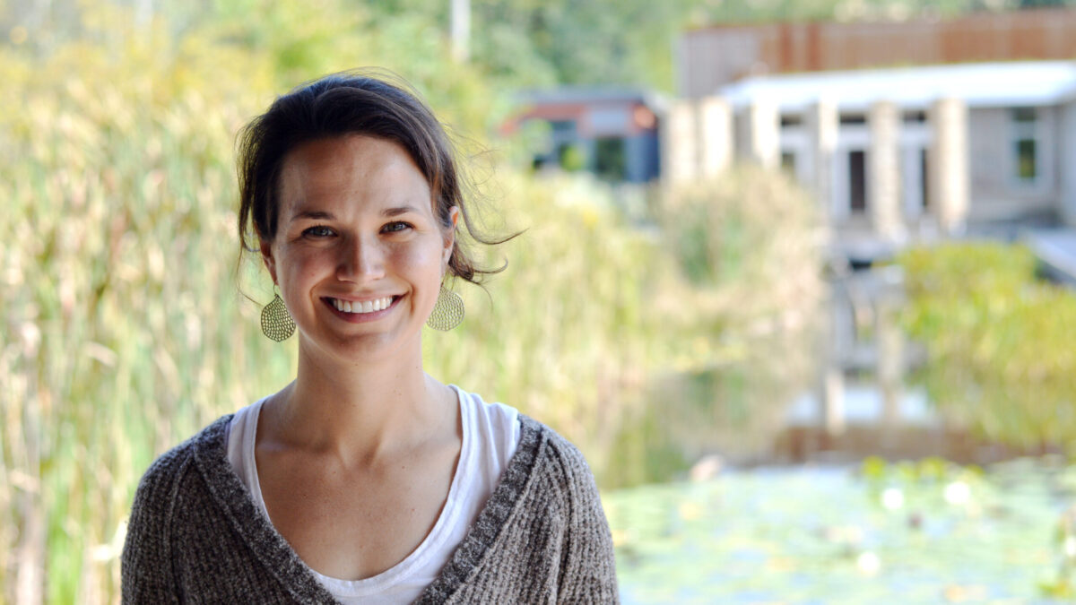 Adult with short dark brown hair smiling in profile