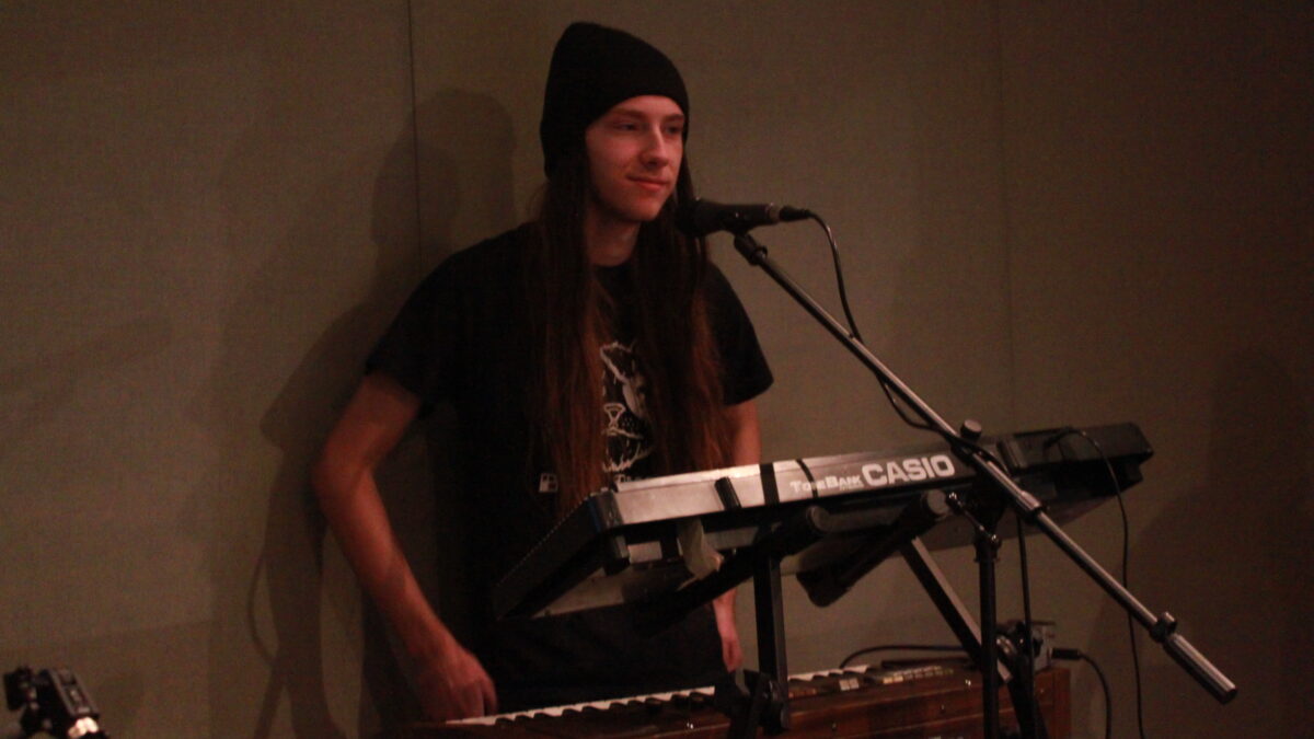 Adult playing synthesizers in a radio studio