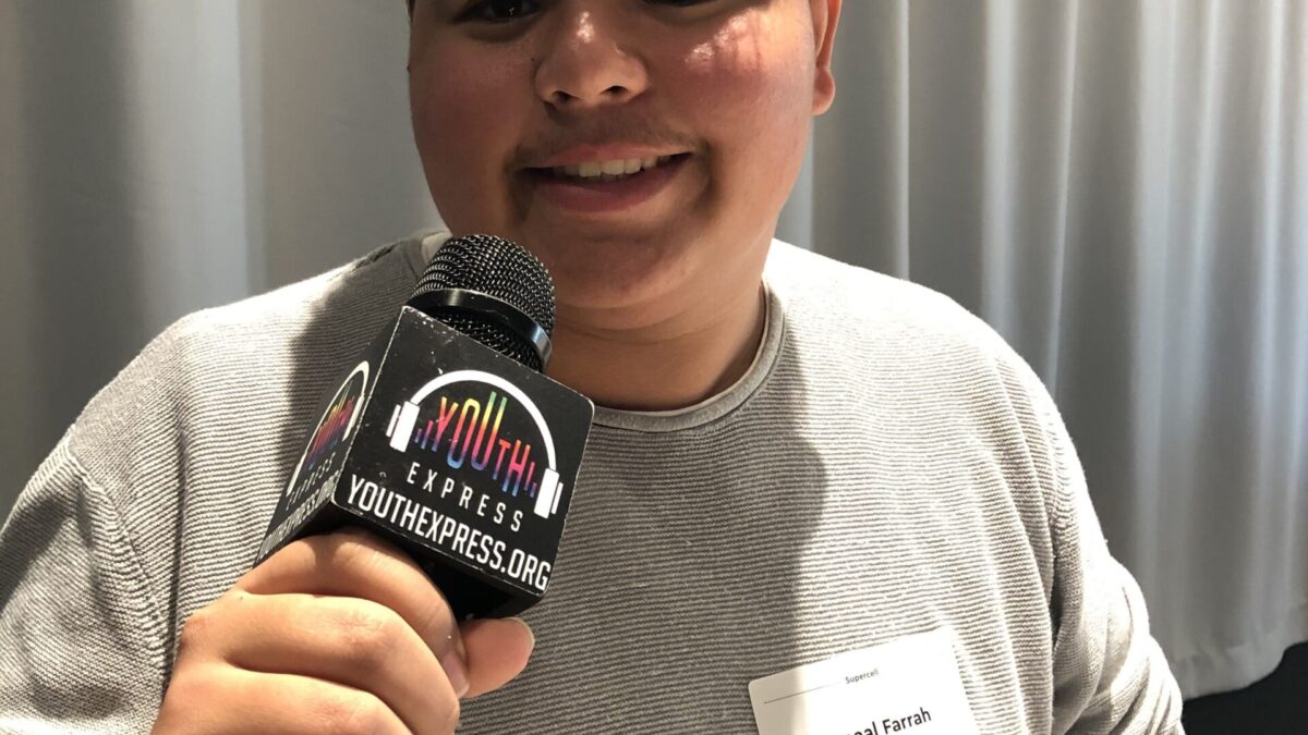 Person holding a microphone and smiling in profile