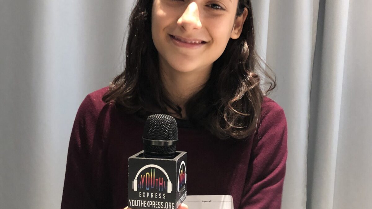 Adult holding a microphone and smiling in profile
