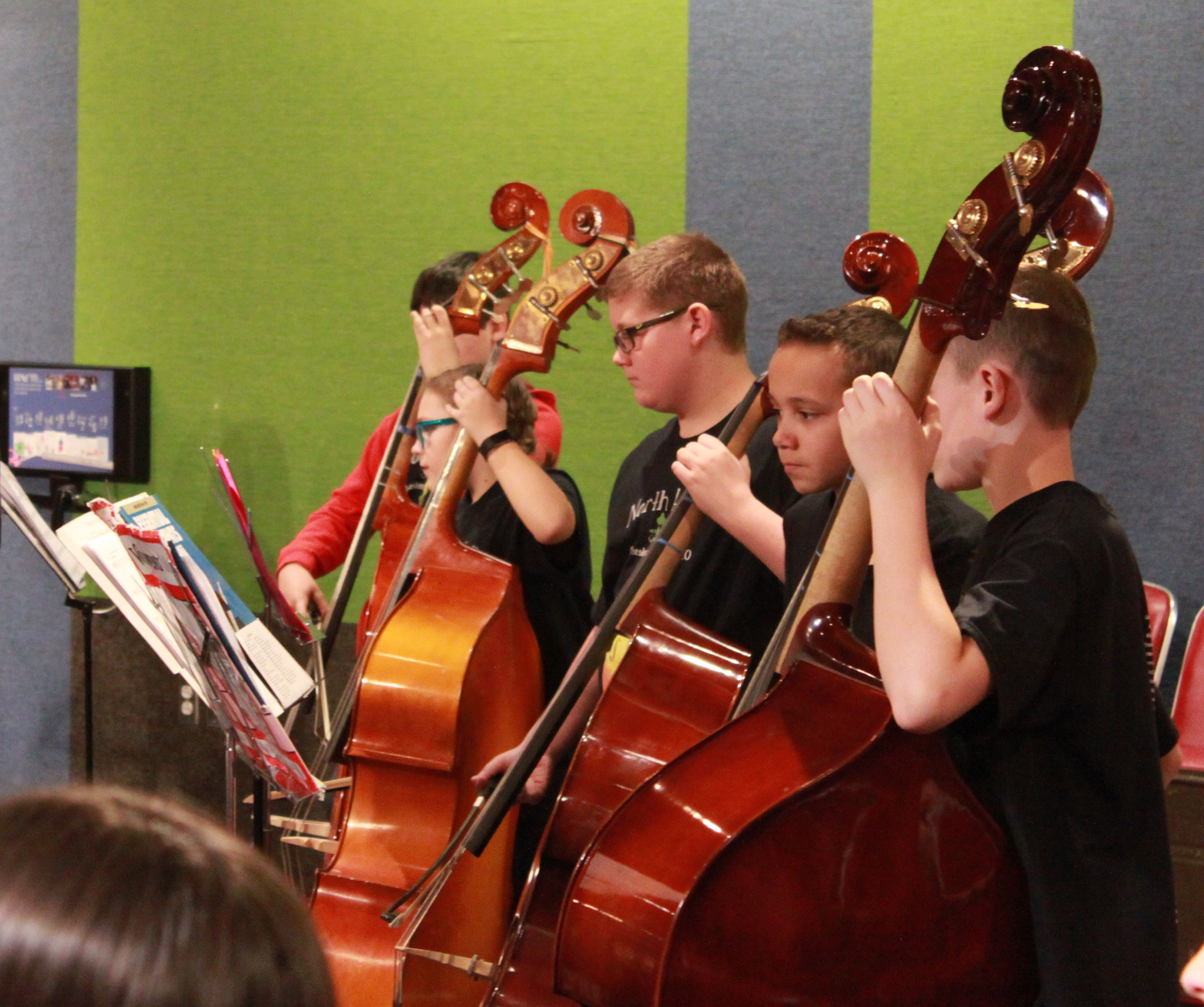 Five youths playing string bass in a youth orchestra