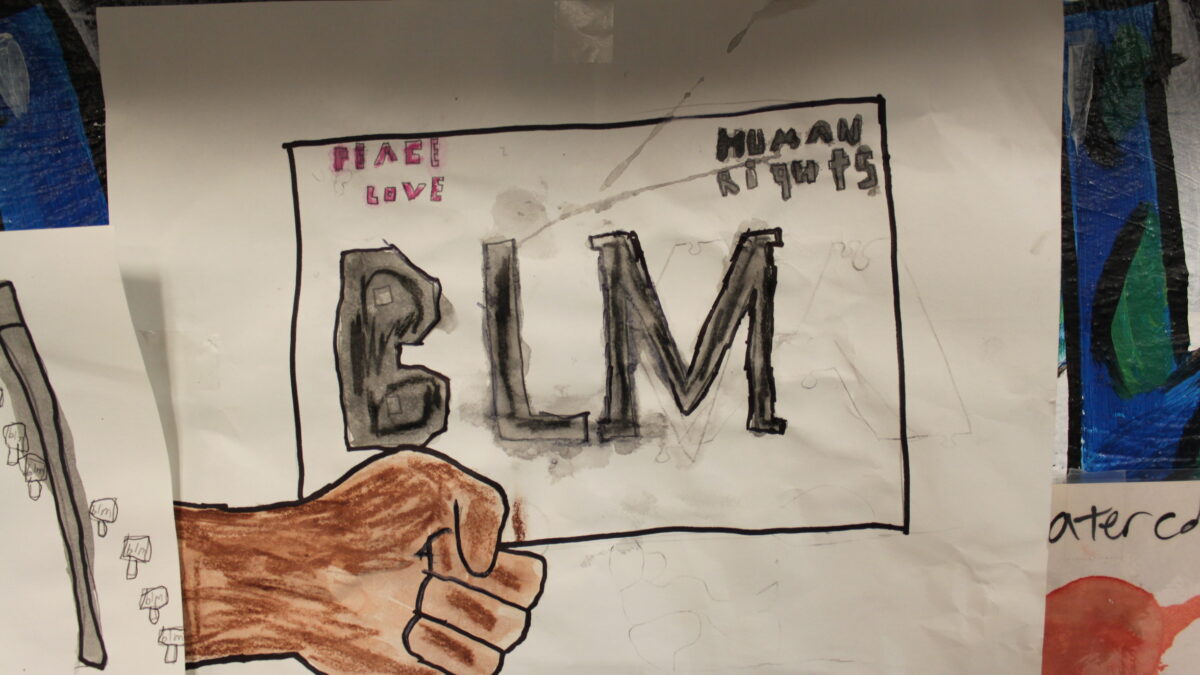 A drawing of a brown fist and a black rectangle with the text "Peace Love" written in pink in the top left corner, "Human Rights" written in gray in the top right corner, and "BLM" written in large gray letters in the center