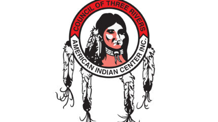 A cartoon graphic of a stereotypical Native American, with the text "Council of Three Rivers" and "American Indian Center Inc." superimposed on a circle surrounding the Native American, with four feathers hanging from the circle