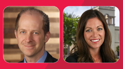 and adult with short gray and brown hair and an adult with long brown hair smiling in profile