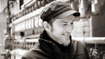 Black and white picture of an adult with a hat and jacket on