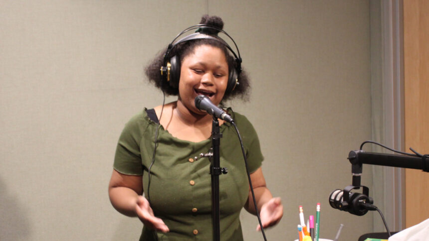 Teen wearing hedphones singing into a microphone