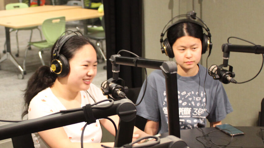 Two teens wearing headphones being interviewed in a radio studio