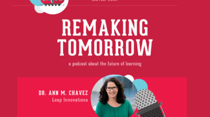 Adult with long brown hair, glasses, and green shirt sitting in profile