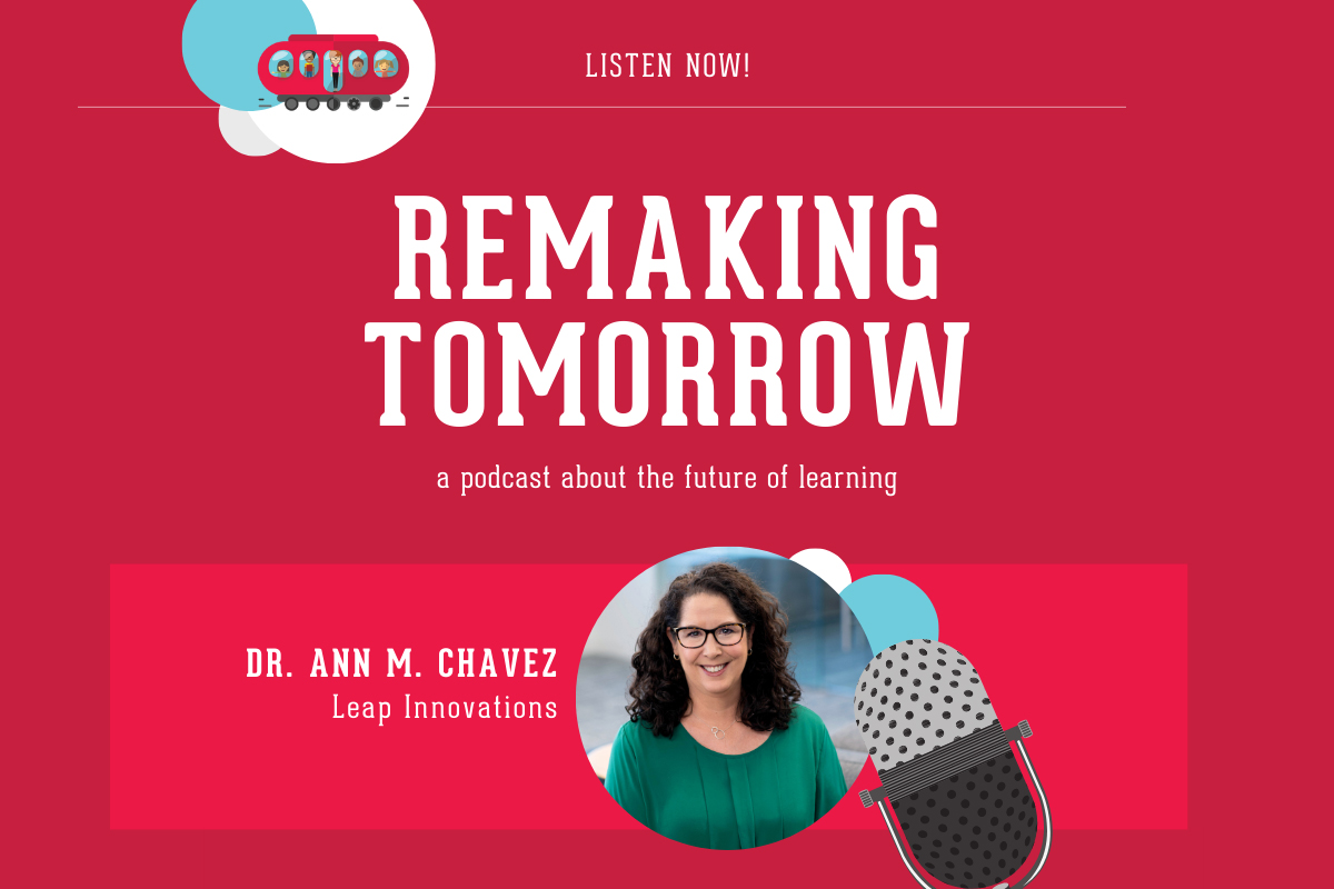 Adult with long brown hair, glasses, and green shirt sitting in profile