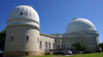 A large white brick building with two large white domes on the roof