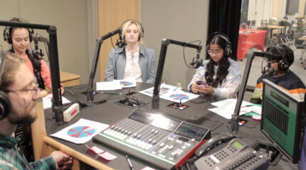 four teens and an adult in a radio studio