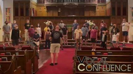 A group of adults singing in a choir in a church