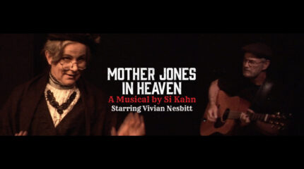 Two adults facing each other, one playing an acoustic guitar, and the text "MOTHER JONES IN HEAVEN" in white, "A Musical by Si Kahn" in red, and "Starring Vivian Nesbitt" in white in the center of the image, all on a black background