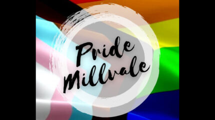 The text "Pride Millvale" in cursive font on a white circle on top of a pride flag