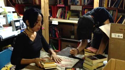Two adults looking down at books in a library