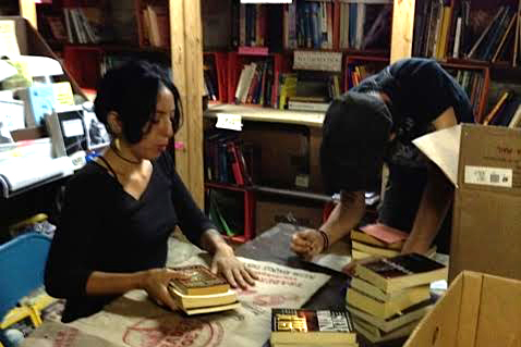 Two adults looking down at books in a library