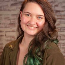 Portrait of a person with brown hair smiling.