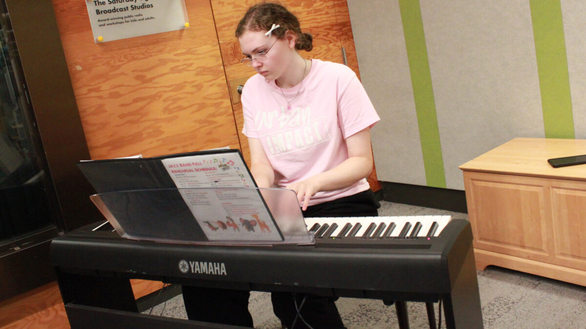 A teen playing a piano keyboard
