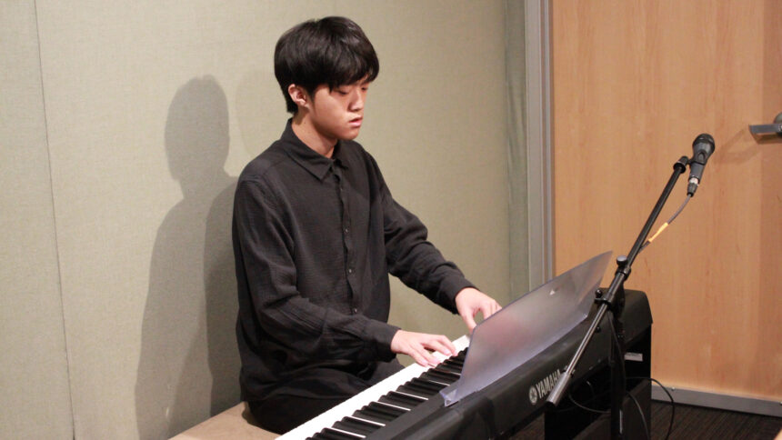 A teen playing a piano keyboard in a radio studio