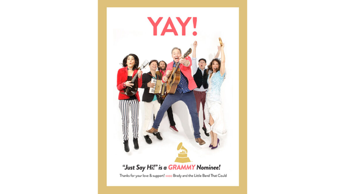Brady-Rymer-Album_wp Six adults, three holding instruments, cheering in front of a white background, along with the text "Yay!" in red above and "Just Say Hi! is a GRAMMY Nominee!" in black underneath, with GRAMMY being written in pink