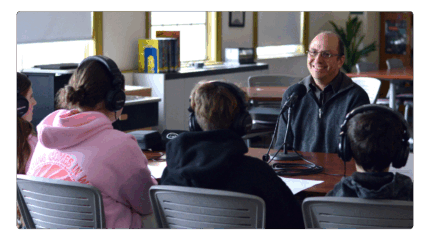 Person with glasses being interviewed.