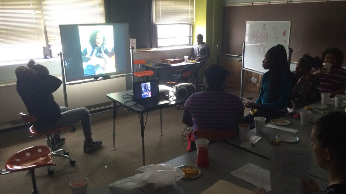 Six youth looking at a projected screen in a classroom