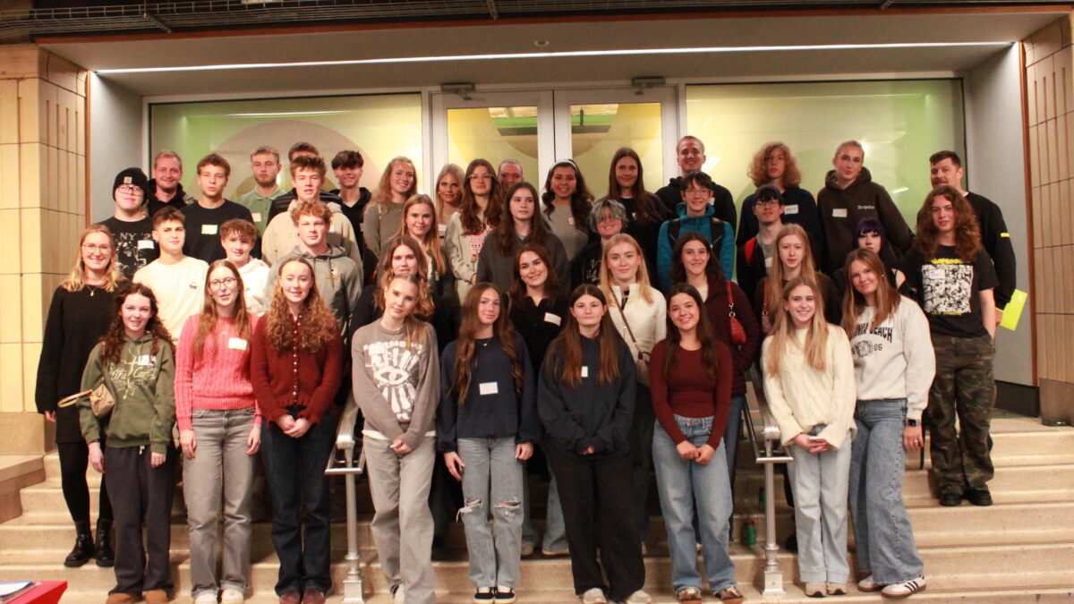 Forty one teens and one adult smiling while standing on a staircase