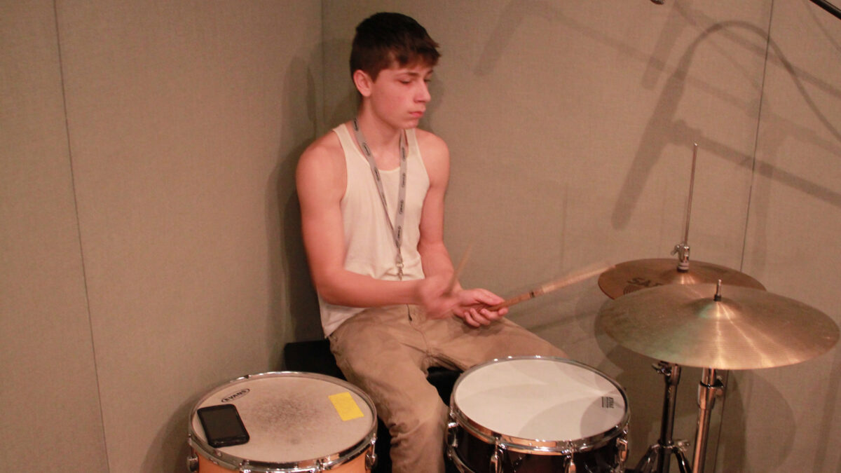 IMG_7877_wp A teen playing a drum set in a radio studio