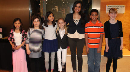 Six youth and an adult smiling and posing in profile