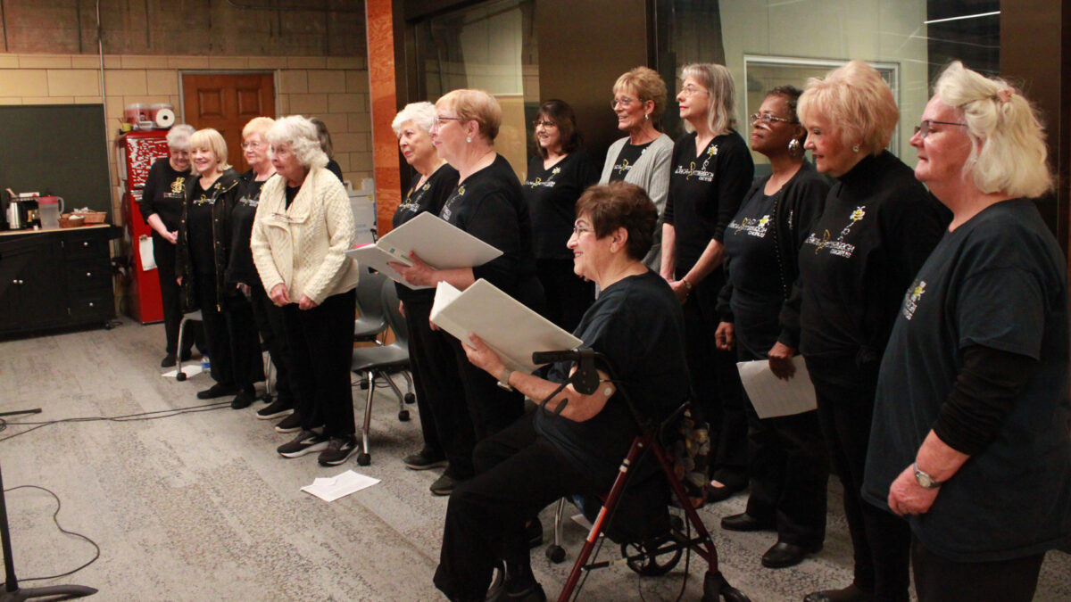 A group of fifteen adults singing in a choir