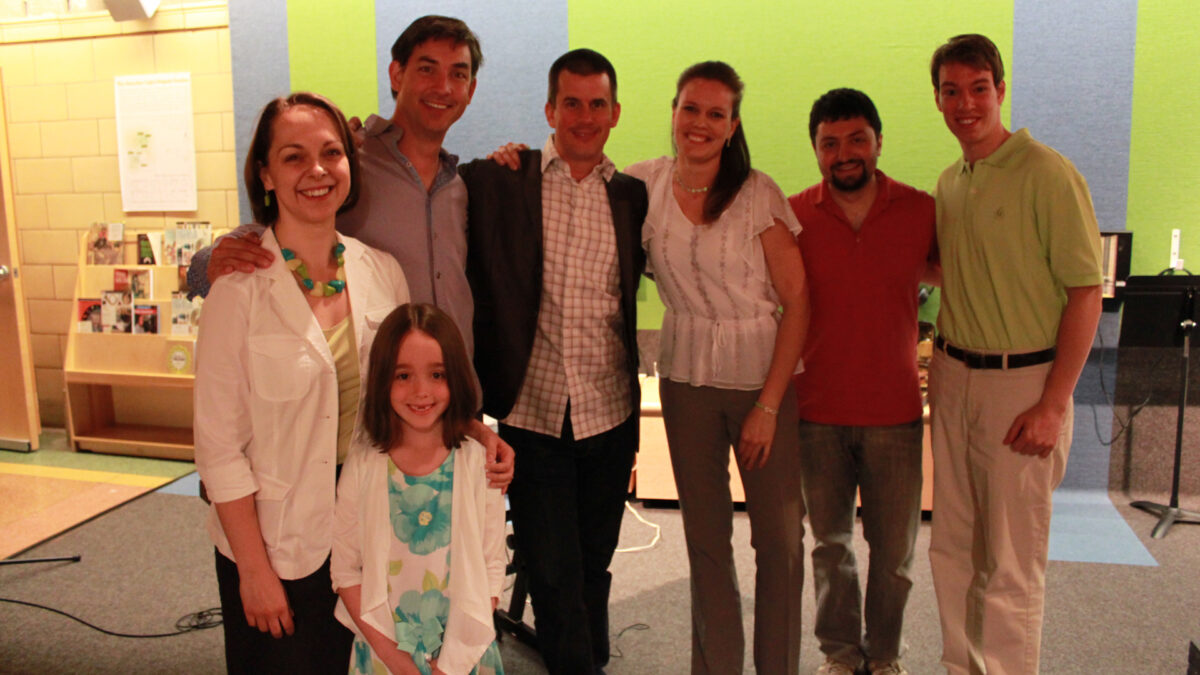 Six adults and one child smiling and posing in profile