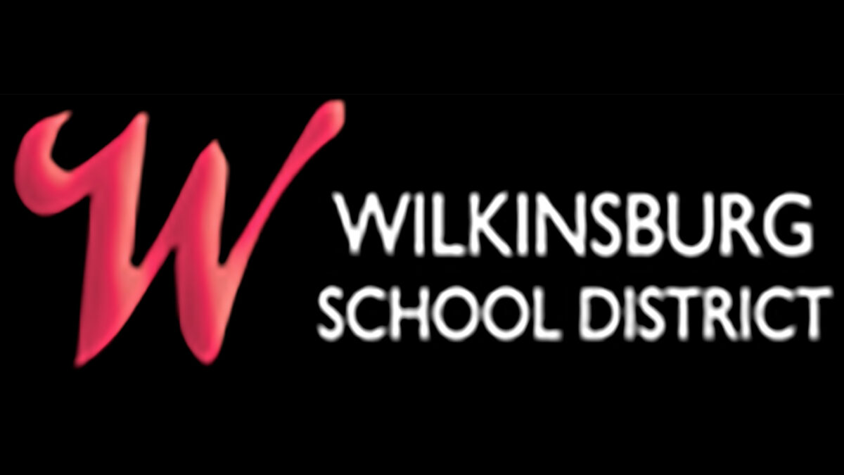 A large red letter W, along with the text "Wilkinsburg School District" in white, all on a black background