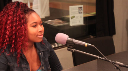 A teen speaking into a microphone in a radio studio